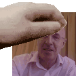 a hand is holding a piece of paper over a man 's face .