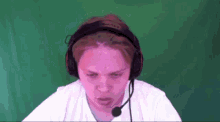a man wearing headphones and a microphone looks angry
