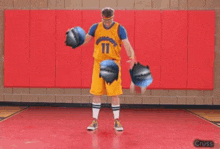 a basketball player with the number 11 on his jersey is holding two balls