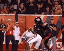 a football player wearing a black helmet with the letter u on it