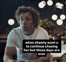 a man sitting at a table with a caption that says when shawty want u to continue chasing