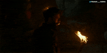 a man is holding a torch in a dark room and the hashtag pranay_varma is below him
