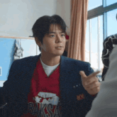 a young man wearing a red shirt that says baksa