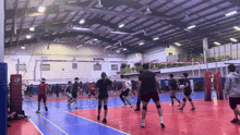 a group of people are playing volleyball in a gym with the number 19 on the back of the jersey