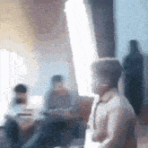 a blurry picture of a man holding a lightsaber in a room .