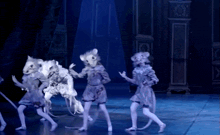 a group of children dressed in mice costumes are dancing on a stage