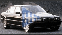 a black bmw is parked on the side of the road in front of a hill .