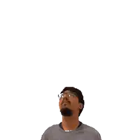 a man with glasses looks up at a green cross above his head