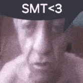 a close up of a man 's face with the words smt < 3 written on it .