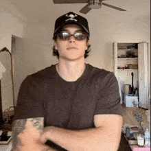 a man wearing sunglasses and a black hat with skulls on it