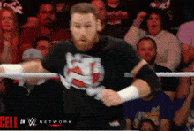 a man in a wrestling ring with a cell on w network logo