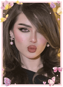 a close up of a woman 's face surrounded by butterflies