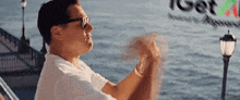 a man wearing sunglasses is sitting on a boat in front of a sign that says get a