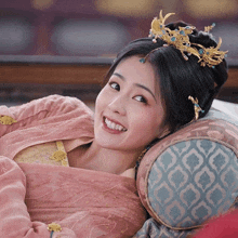 a woman wearing a tiara is smiling while laying on a bed