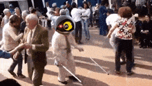 a group of people are dancing with a man wearing a mask that says ' m ' on it