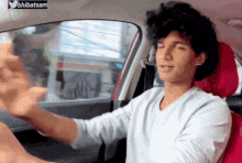 a man in a car with a sticker on the windshield that says ' bhibatsam '