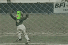 a baseball player wearing a green mask is swinging a bat