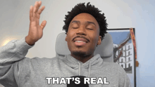 a man in a gray hoodie says that 's real with his eyes closed