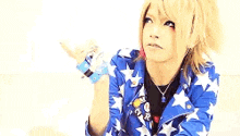 a girl with red and blonde hair is wearing a blue and white jacket with stars .