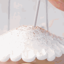 a woman with leopard print nails is piping chocolate into a white circle