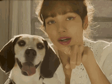 a woman and a dog are posing for a picture and the woman is pointing at the dog