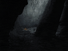 a person holding a gun in a dark room with a ring on it