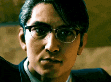 a close up of a man 's face with glasses