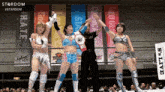 a group of female wrestlers are standing in front of banners that say stardom