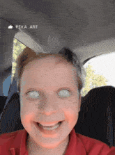 a young boy in a red shirt with white eyes is smiling in the back seat of a car ..