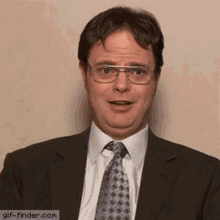a man wearing glasses and a suit is making a funny face
