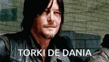 a close up of a man 's face with the words torki de dania written on the bottom
