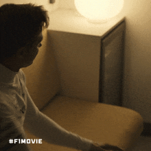 a man sitting in a chair with #f1movie on the bottom right