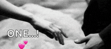 a black and white photo of a person holding another person 's hand with the words one written above them