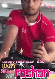 a man in a red shirt is taking a picture of himself with his phone .