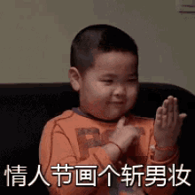 a little boy is sitting on a couch clapping his hands in a foreign language .