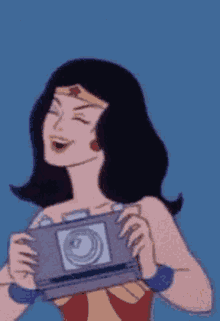 wonder woman is holding a camera and smiling
