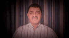 a man with a mustache is wearing a striped shirt and making a funny face