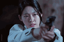 a close up of a woman holding a gun with a watermark that says " noticias "