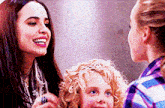 two women and a little girl are talking to each other .