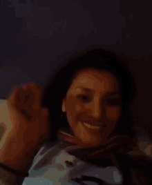 a woman with a scarf around her neck is smiling and looking at the camera