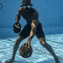 a man is standing in a swimming pool holding a ball .