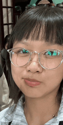 a woman wearing glasses and a striped shirt