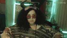 a woman wearing a horned headband and sunglasses stands in front of a happy halloween sign