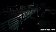 a man in a brown leather jacket is standing next to a railing in the dark .