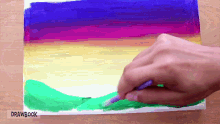 a person is painting a colorful landscape with drawbook written on the bottom
