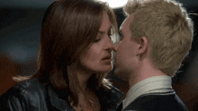 a man and a woman are kissing and the woman is wearing a black jacket