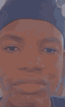 a close up of a person 's face wearing a blue hat .