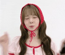 a woman wearing a red hat and a pink top