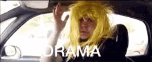 a man in a yellow wig is sitting in the back seat of a car with the word drama written below him