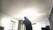 a man with his arms outstretched looks up at the ceiling